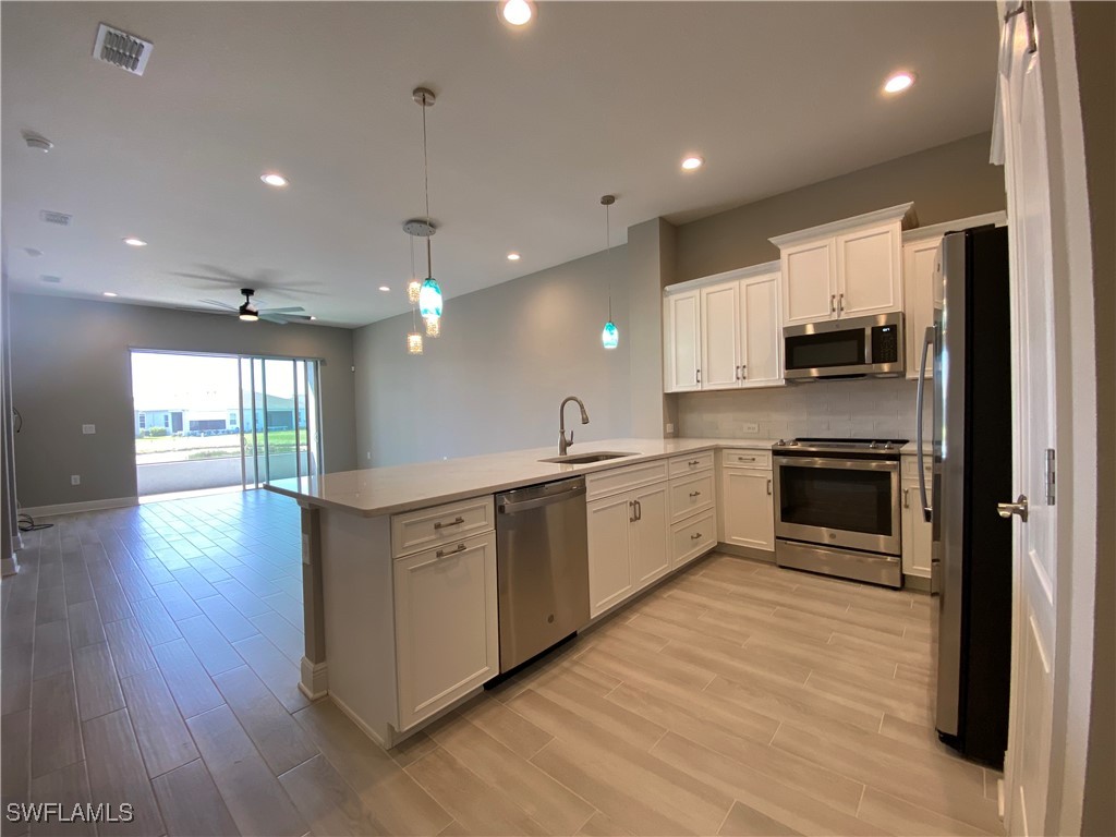 1927 Nottingham Trail Punta Gorda, FL 33980 - Photo 8 of 35 a large kitchen with stainless steel appliances kitchen island a large counter top and a stove top oven
