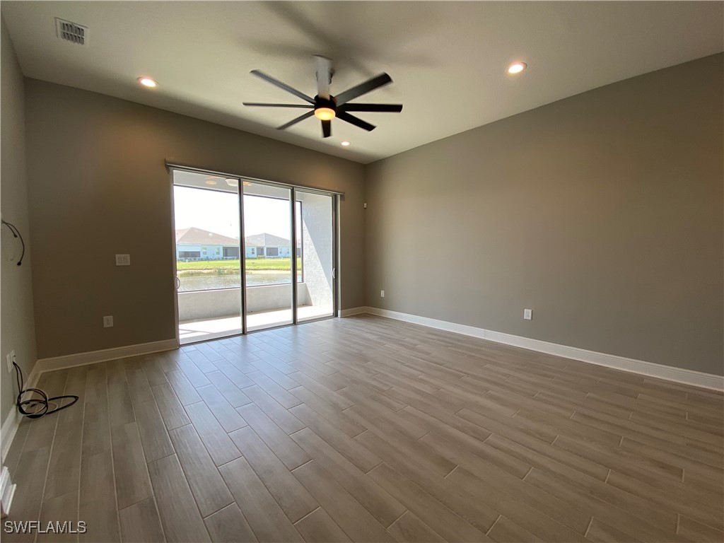 1927 Nottingham Trail Punta Gorda, FL 33980 - Photo 10 of 35 an empty room with wooden floor fan and windows