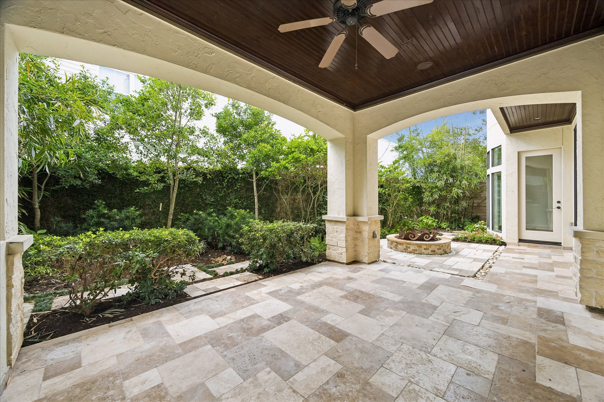 2246 Branard Street Houston, TX 77098 - Photo 39 of 40 Thoughtfully designed outdoor spaces blend covered seating areas, lush greenery, and a sculptural fire feature for a resort-like atmosphere.