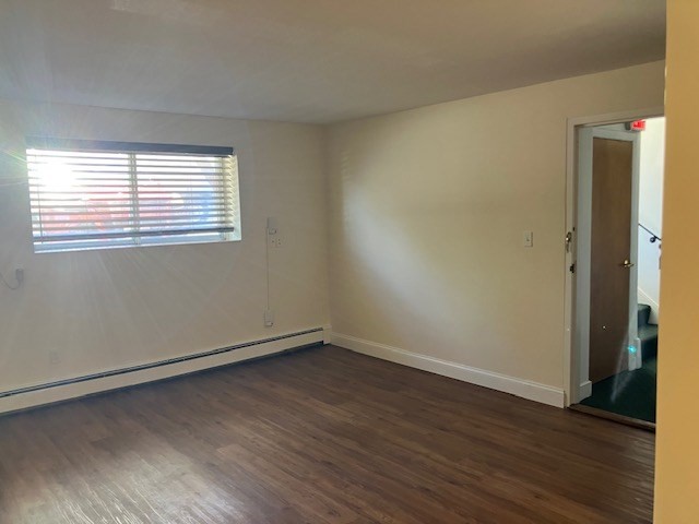 116 Trapelo Road, Unit 4 Waltham, MA 02452 - Photo 4 of 4 a view of an empty room with wooden floor and a window