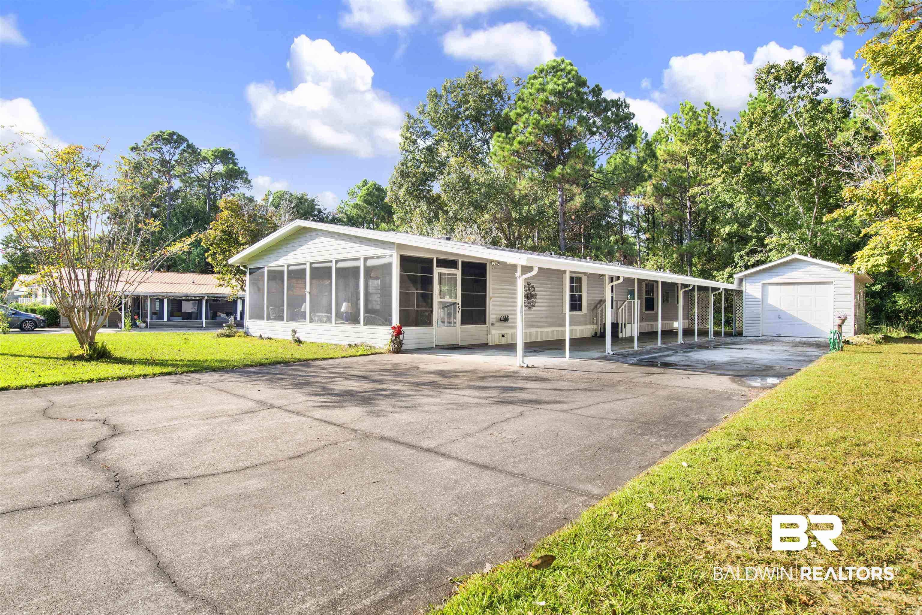 1216 Ridgewood Drive Lillian, AL 36549 - Photo 28 of 29 Single story home featuring a front lawn, asphalt driveway, a detached garage, and an outbuilding