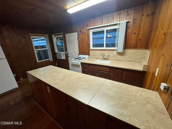 a kitchen with a sink a counter top space and living room