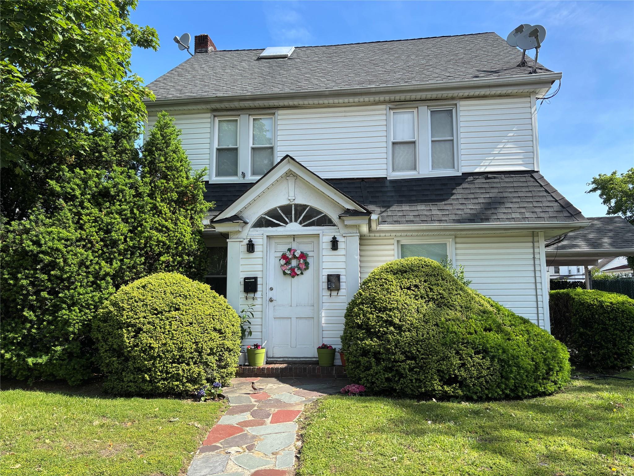 401 Merrick Road Rockville Centre, NY 11570 - Photo 1 of 1 View of front of property with a shingled roof, a chimney, and a front lawn