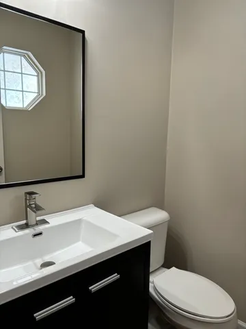 a bathroom with a sink a toilet and mirror