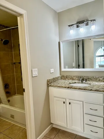 a bathroom with a granite countertop sink and a mirror