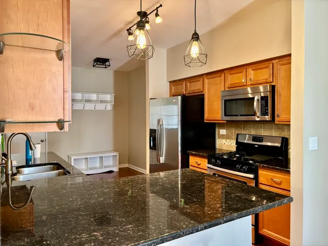 a kitchen with a sink a counter top space cabinets and stainless steel appliances