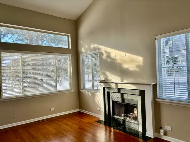 a living room with fireplace furniture and a floor to ceiling window