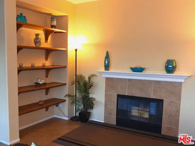 a living room with furniture cabinets and a large window