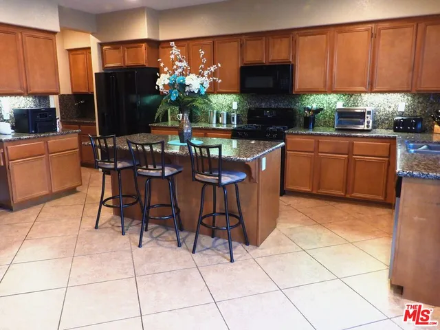 a kitchen with stainless steel appliances granite countertop a stove a sink a microwave and a refrigerator