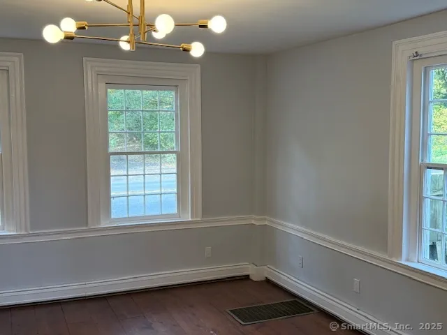 en empty room with wooden floor and windows