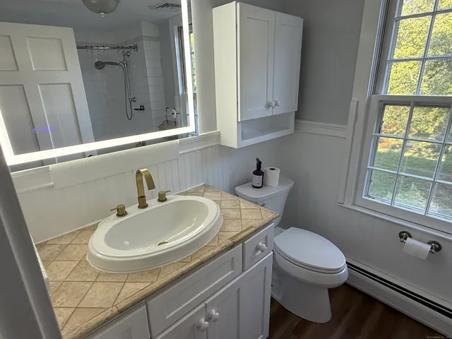 a bathroom with a sink a toilet and a mirror