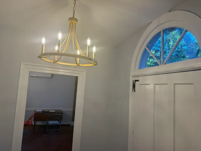 a room with water heater and wooden cabinets