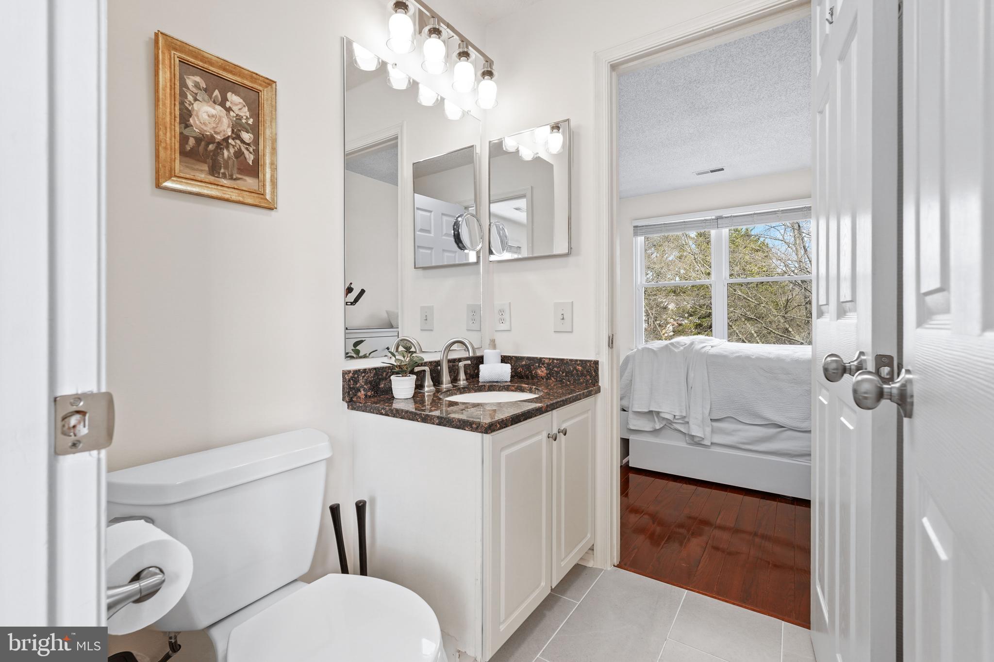 12901 Churchill Ridge Circle, Unit 13 Germantown, MD 20874 - Photo 23 of 44 a bathroom with a granite countertop toilet sink and mirror