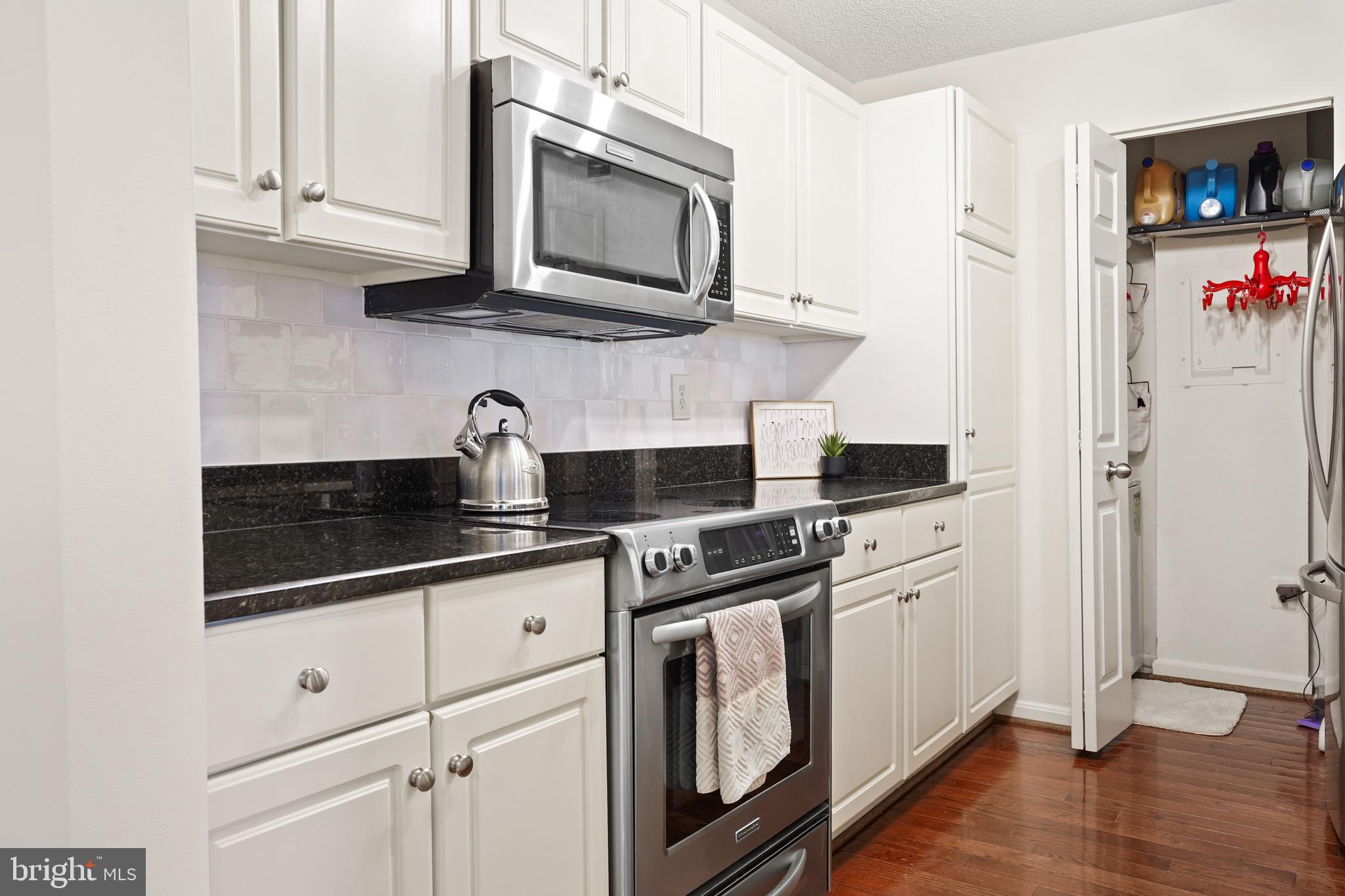 12901 Churchill Ridge Circle, Unit 13 Germantown, MD 20874 - Photo 9 of 44 a kitchen with stainless steel appliances granite countertop a sink a stove and microwave