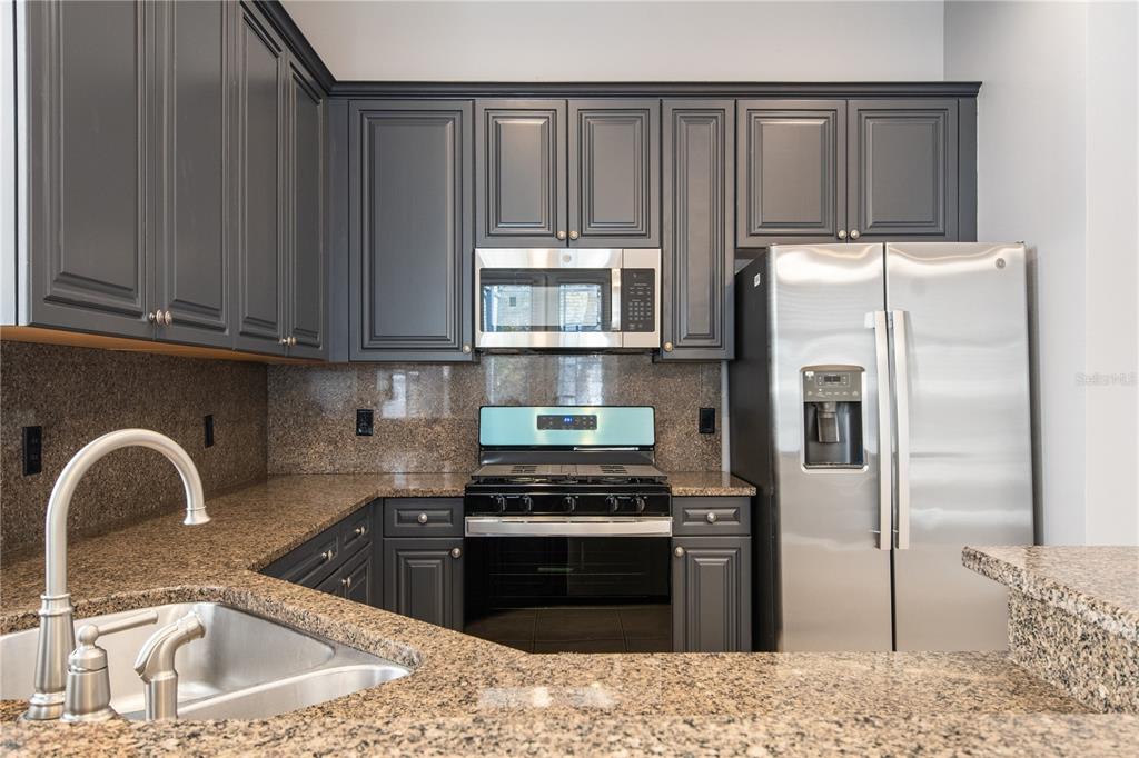 13118 Sunkiss Loop Windermere, FL 34786 - Photo 16 of 52 a kitchen with a sink a refrigerator and cabinets