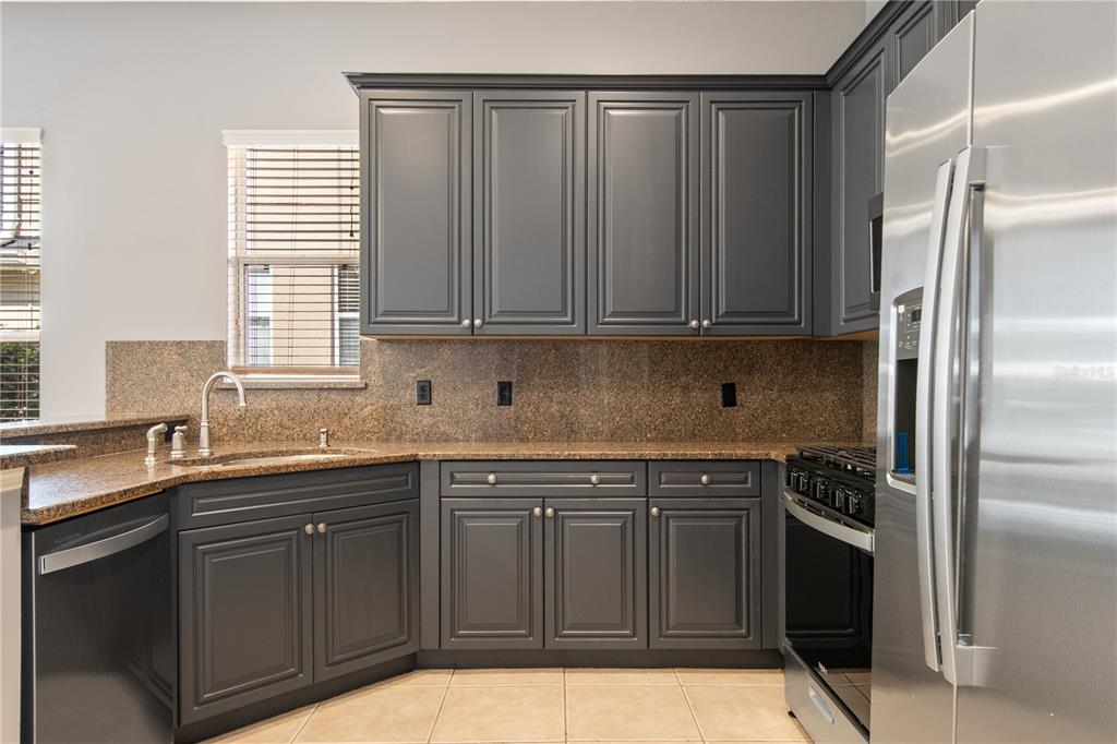 13118 Sunkiss Loop Windermere, FL 34786 - Photo 17 of 52 a kitchen with stainless steel appliances granite countertop a sink stove and refrigerator