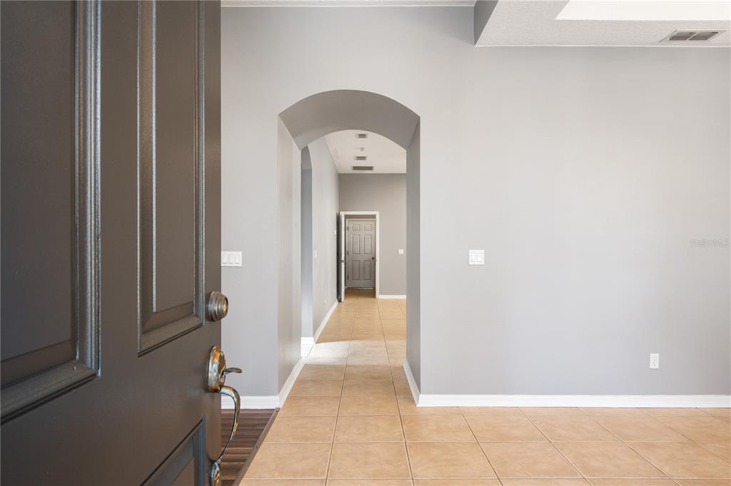 13118 Sunkiss Loop Windermere, FL 34786 - Photo 4 of 52 a view of a hallway with wooden floor and a bathroom