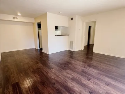 a view of empty room with wooden floor and window