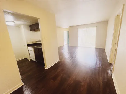 an empty room with wooden floor and a window