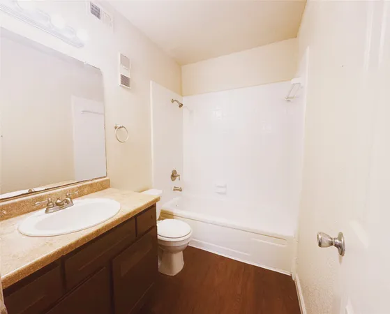 an empty room with wooden floor and ceiling fan