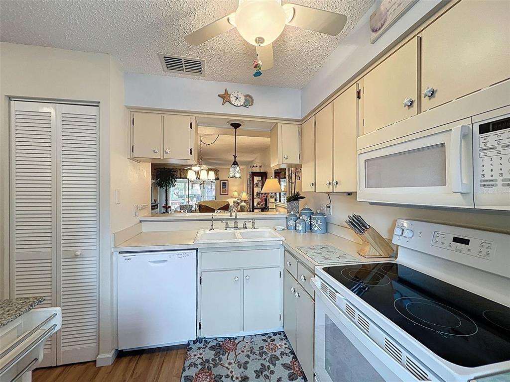6433 Tina Drive, Unit 12 New Port Richey, FL 34653 - Photo 5 of 24 a kitchen with stainless steel appliances kitchen island granite countertop a sink a stove a microwave and cabinets
