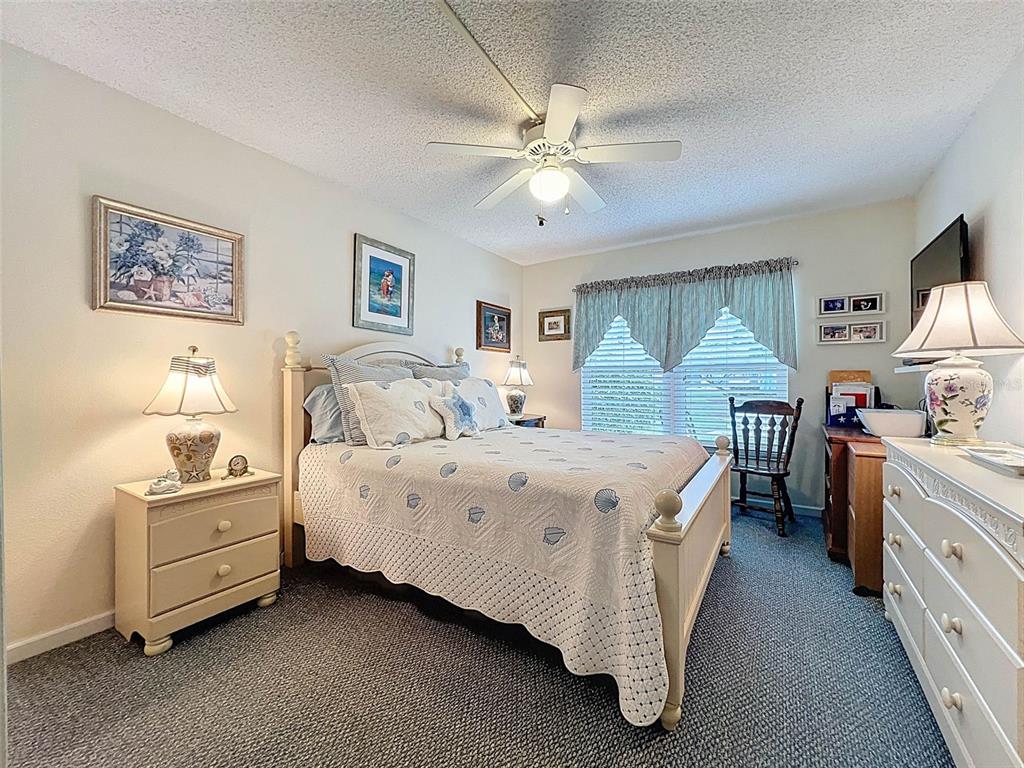 6433 Tina Drive, Unit 12 New Port Richey, FL 34653 - Photo 8 of 24 a spacious bedroom with a bed and a chandelier