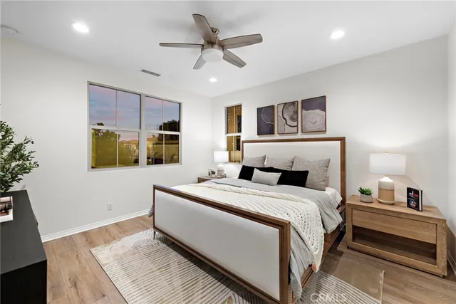 a bedroom with a large bed a chandelier and dresser