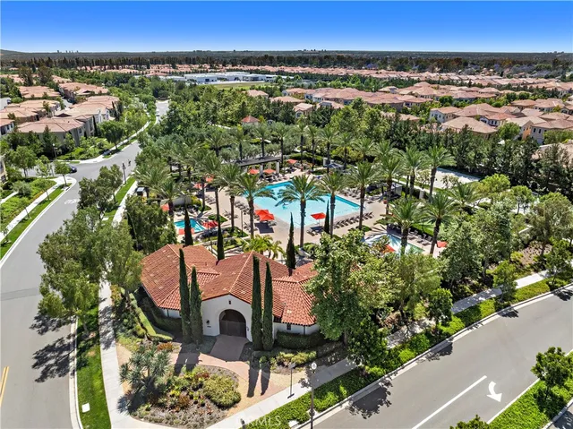 an aerial view of residential houses with outdoor space and trees