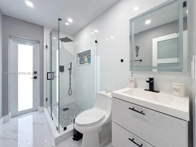 a bathroom with a sink a toilet and shower