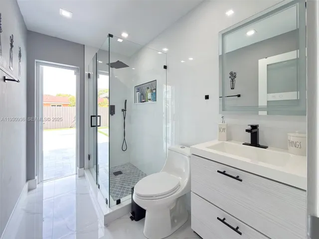 a bathroom with a toilet a sink and glass door