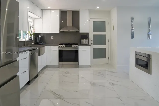 a kitchen with stainless steel appliances granite countertop a stove top oven and sink