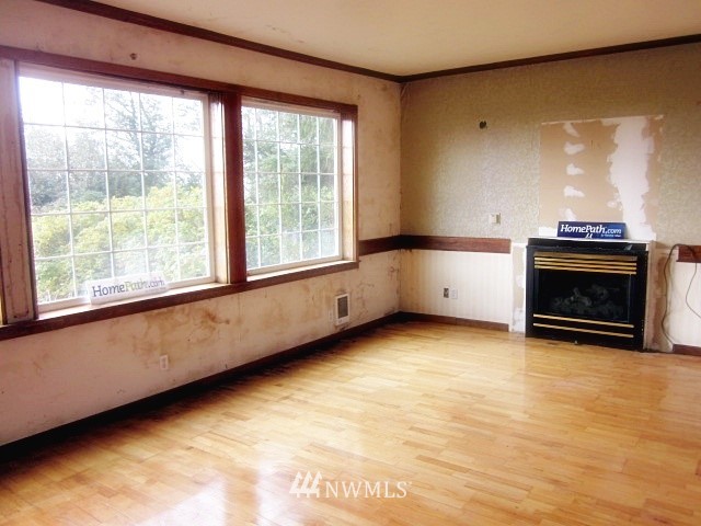 266 Stringtown Road Ilwaco, WA 98624 - Photo 2 of 13 a view of an empty room with a fireplace and a window