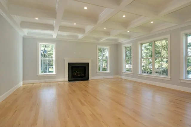 an empty room with windows and fireplace