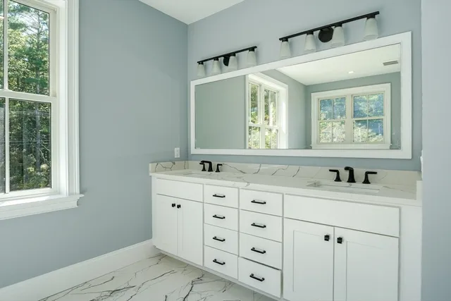 a bathroom with a sink mirror and a window