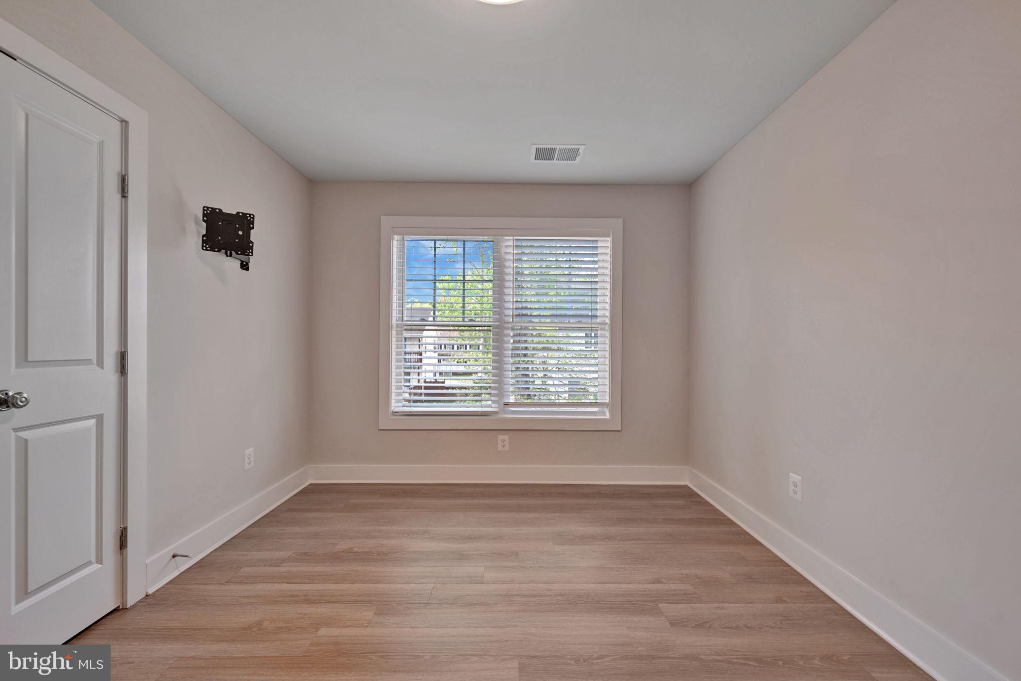 1205 Hawthorne Street Shady Side, MD 20764 - Photo 19 of 35 a view of an empty room with wooden floor and a window