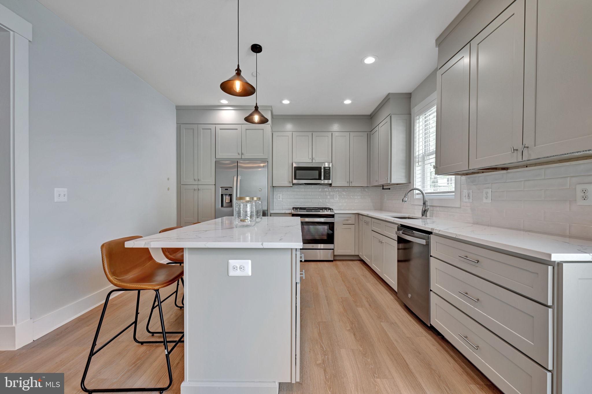 1205 Hawthorne Street Shady Side, MD 20764 - Photo 3 of 35 a kitchen with kitchen island stainless steel appliances a stove a sink cabinets and a wooden floor