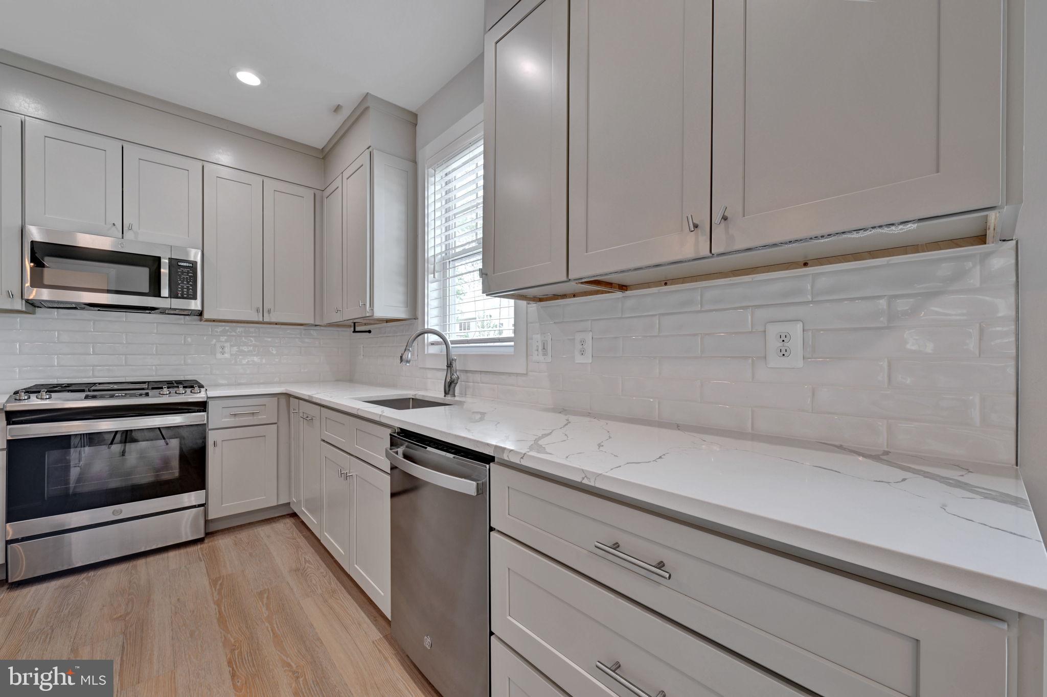 1205 Hawthorne Street Shady Side, MD 20764 - Photo 4 of 35 a kitchen with granite countertop white cabinets stainless steel appliances and a sink