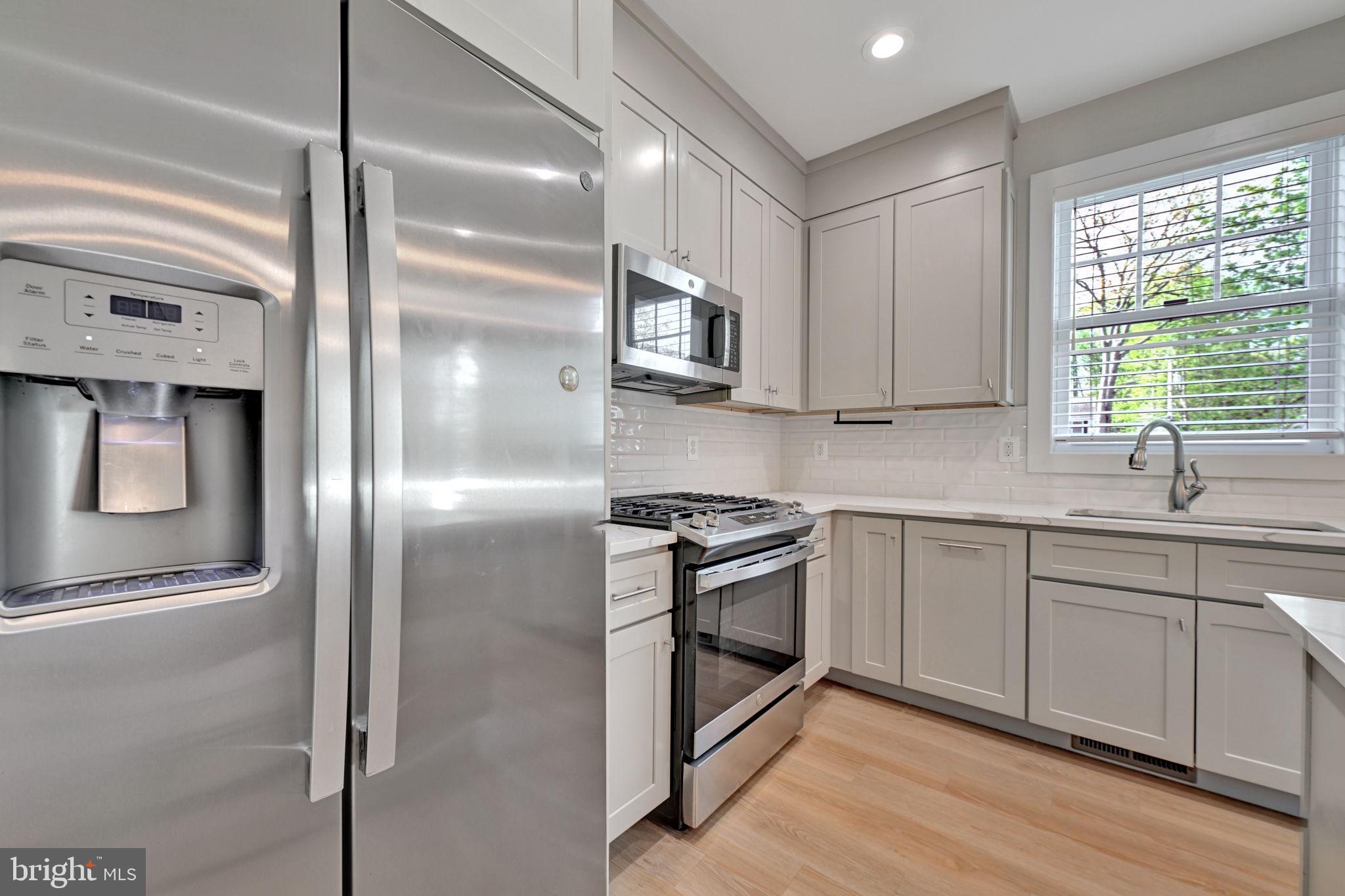 1205 Hawthorne Street Shady Side, MD 20764 - Photo 5 of 35 a kitchen with stainless steel appliances granite countertop a stove a sink and a refrigerator
