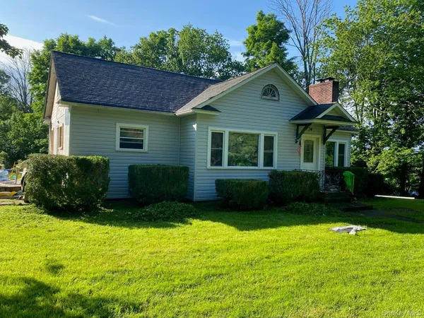 a front view of a house with yard and green space