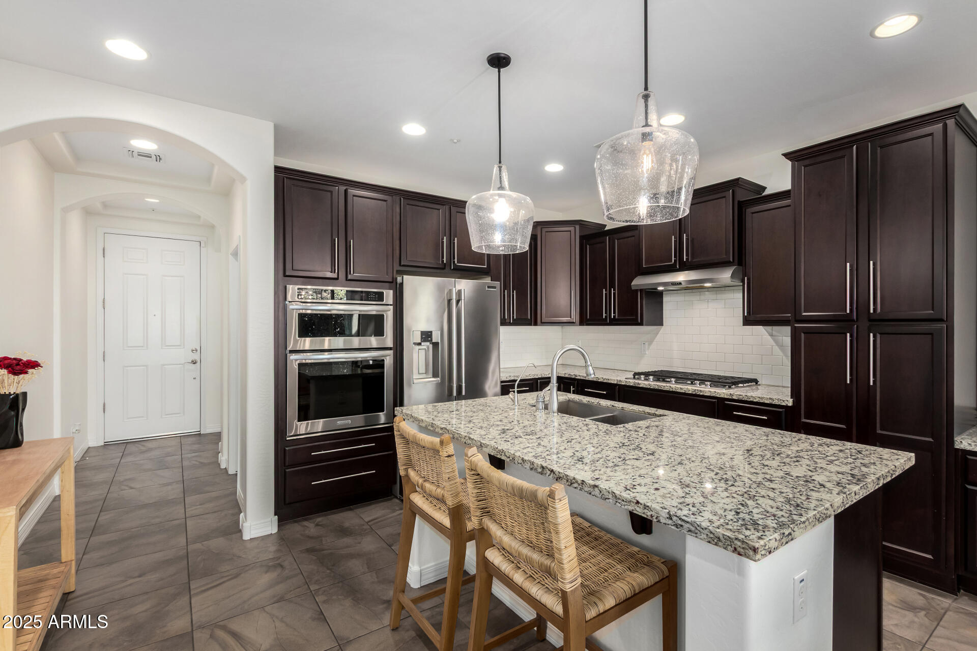 3420 East Indigo Street Gilbert, AZ 85298 - Photo 7 of 27 a kitchen with stainless steel appliances granite countertop a sink refrigerator and cabinets