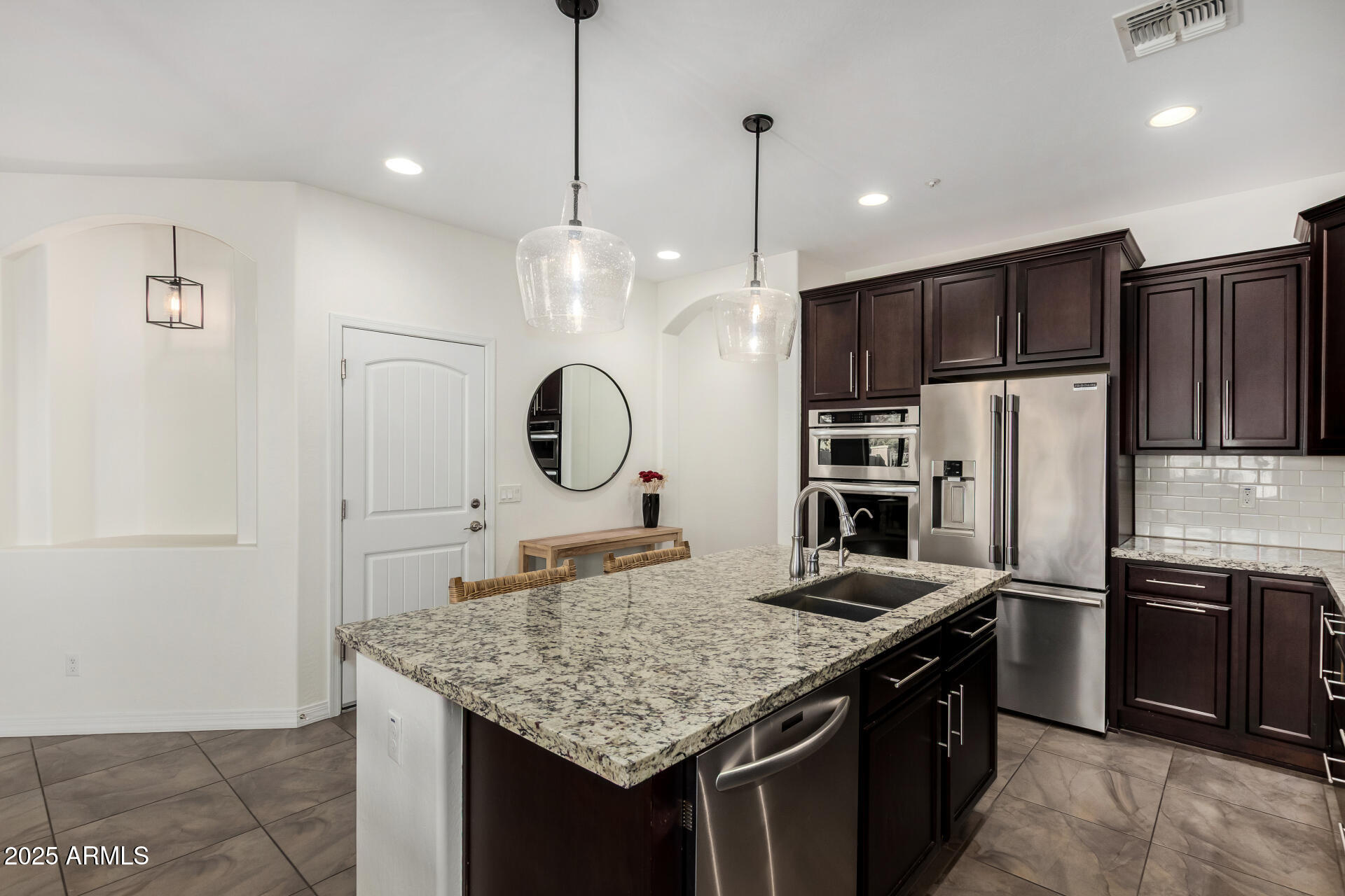3420 East Indigo Street Gilbert, AZ 85298 - Photo 9 of 27 a kitchen with stainless steel appliances granite countertop a sink refrigerator and cabinets