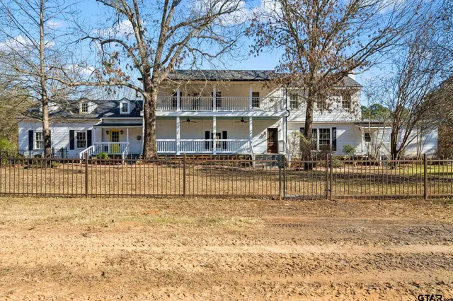 a view of a house with large trees in front of it