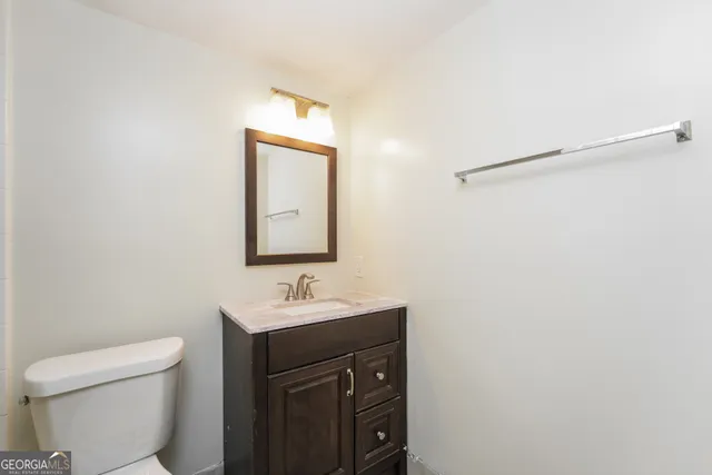 a bathroom with a sink a toilet and mirror