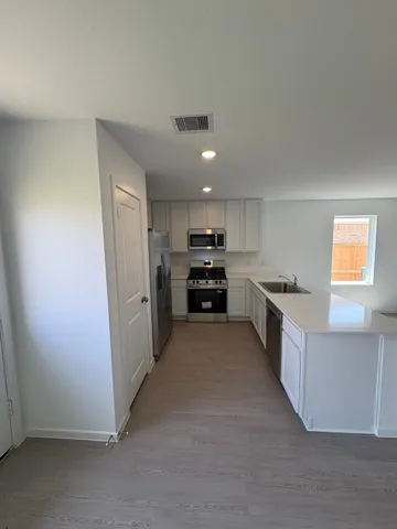 a large kitchen with cabinets and stainless steel appliances