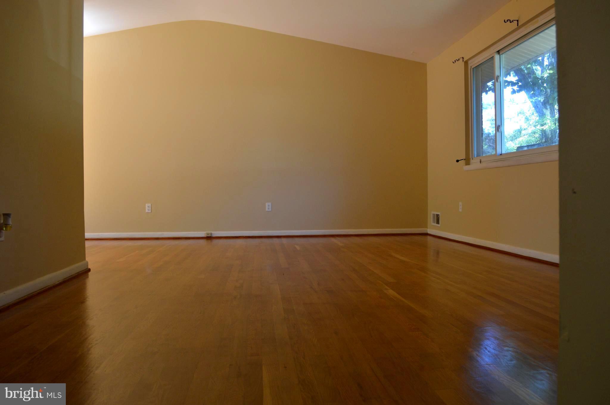 406 Irwin Street Silver Spring, MD 20901 - Photo 5 of 30 a view of an empty room with wooden floor and a window