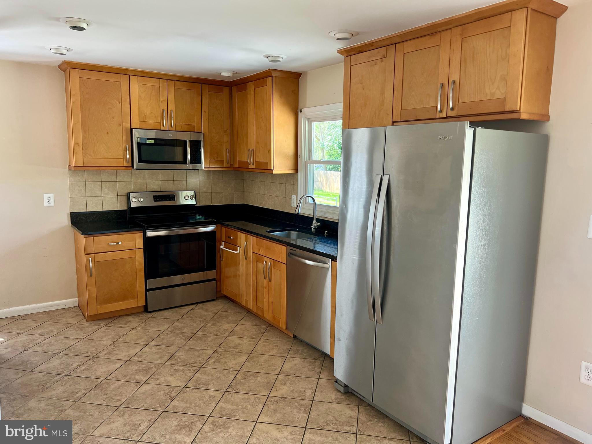 4105 Isbell Street Silver Spring, MD 20906 - Photo 10 of 19 a kitchen with stainless steel appliances granite countertop a refrigerator a stove a sink a microwave and cabinets