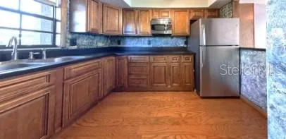a kitchen with stainless steel appliances granite countertop a refrigerator and a sink