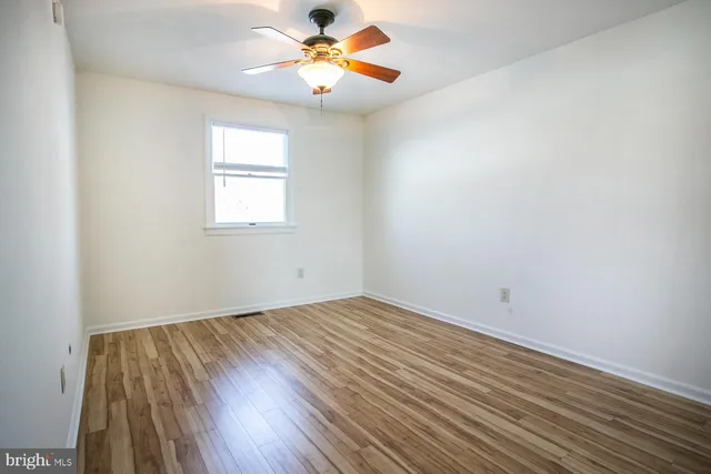 an empty room with a window and wooden floor
