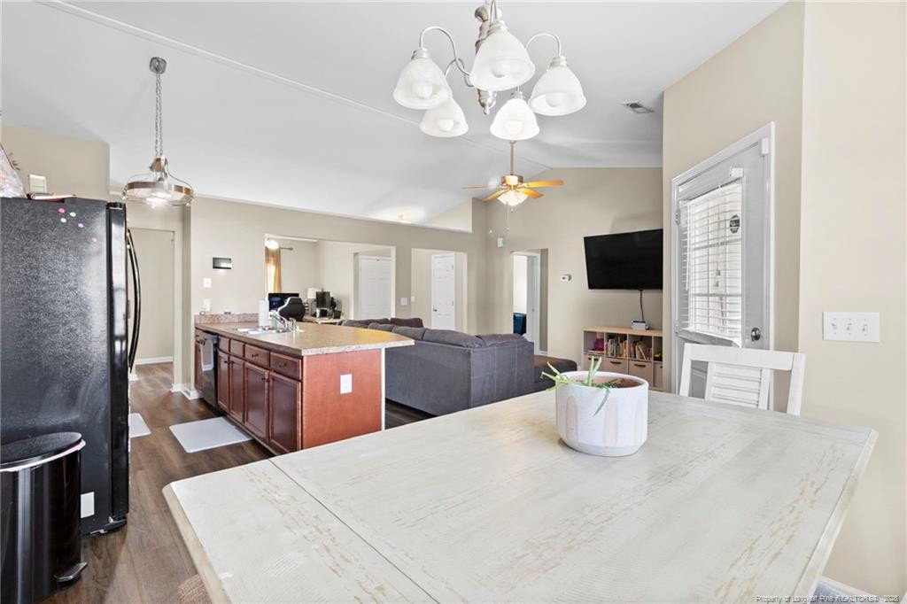 46 Old English Lane Spring Lake, NC 28390 - Photo 17 of 36 a kitchen with stainless steel appliances kitchen island granite countertop a refrigerator a stove top oven a sink dishwasher a dining table and chairs with wooden floor