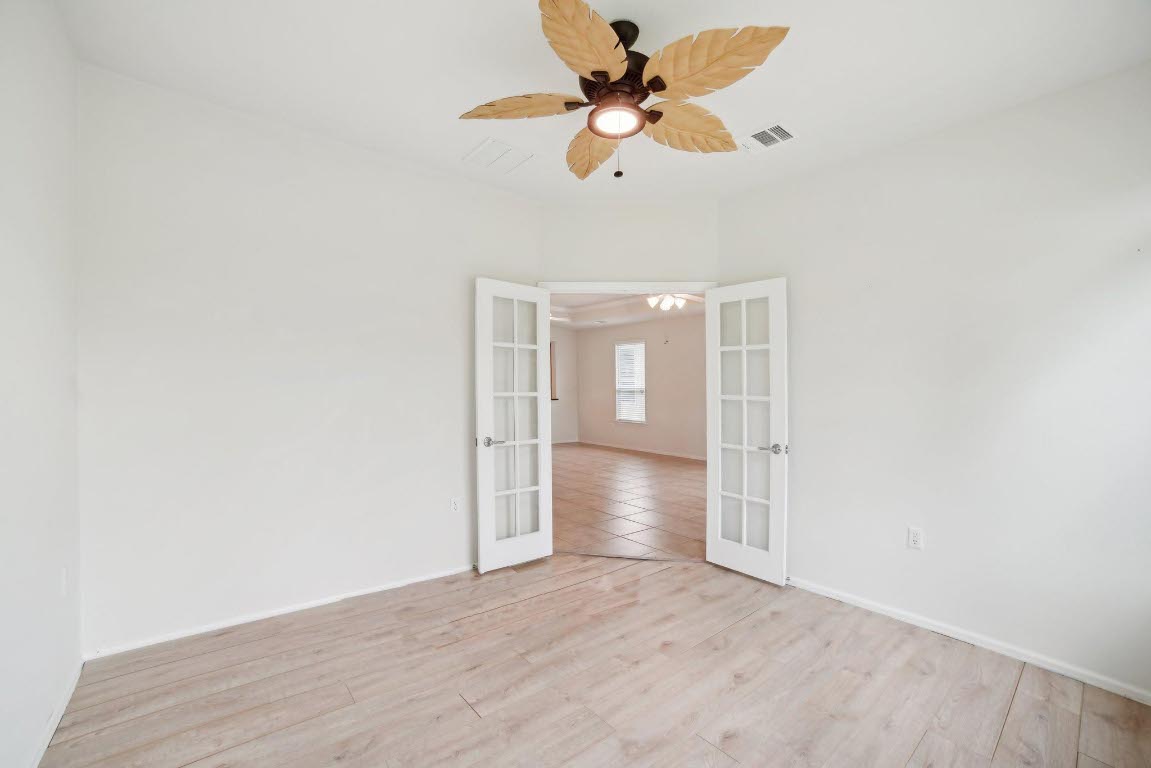 207 Trinity Lane Georgetown, TX 78633 - Photo 25 of 37 an empty room with wooden floor fan and ceiling fan